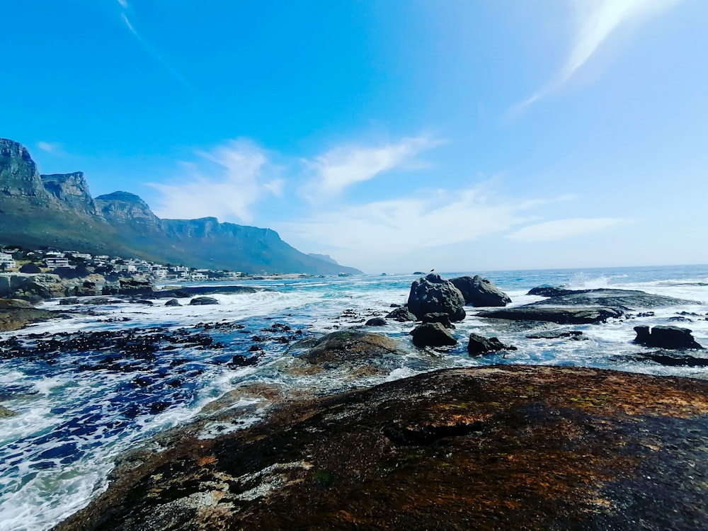 black rock formation on sea shore during daytime