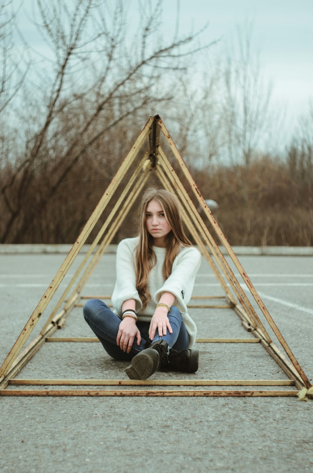 woman in white sweater and blue denim jeans sitting on yellow hammock