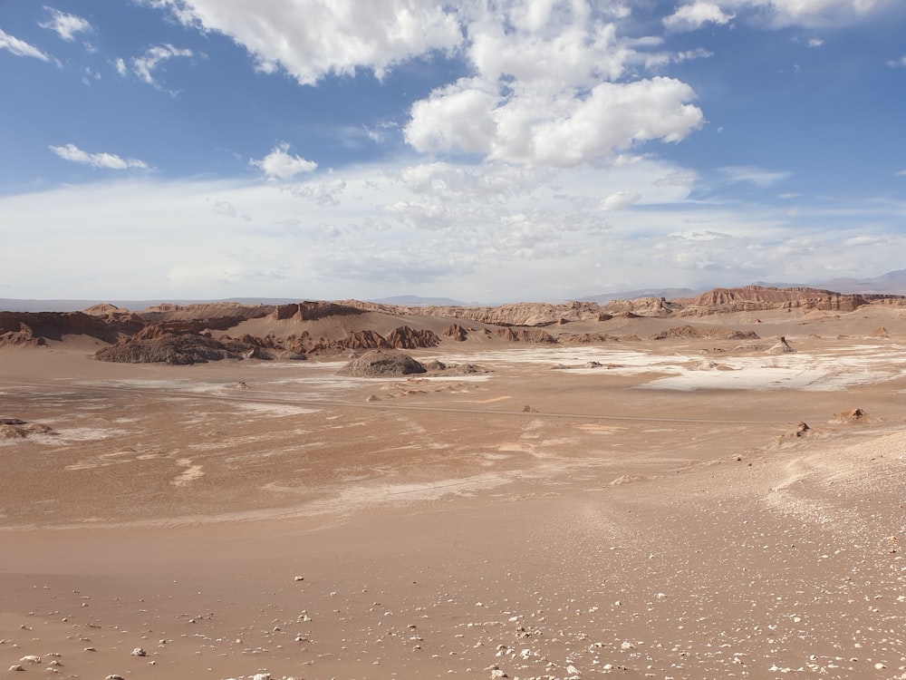 brown sand under blue sky and white clouds during daytime