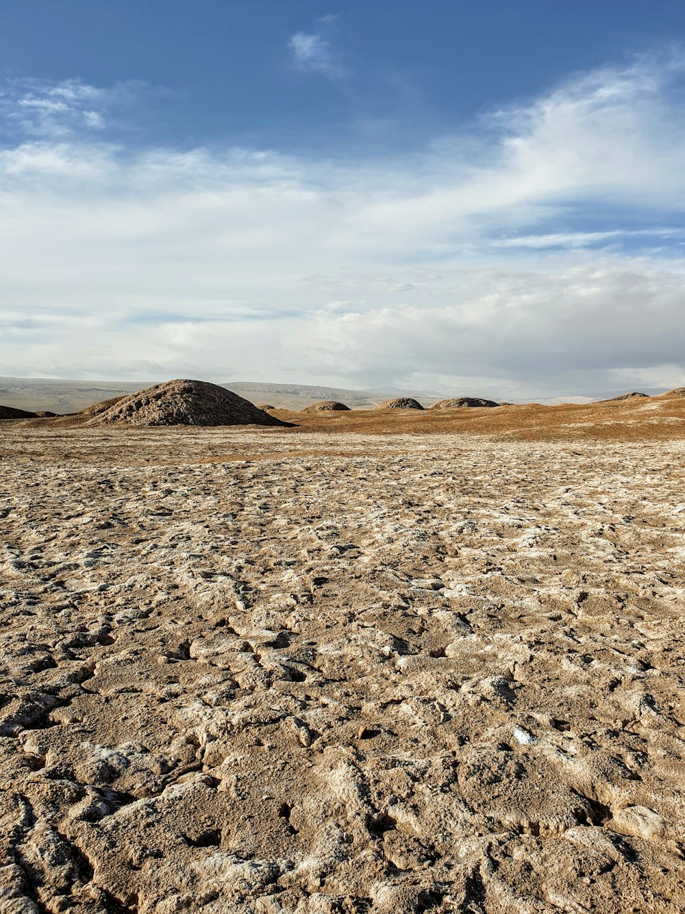 brown sand under white clouds during daytime