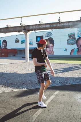 Urban streetwear outfit with oversized cargo shorts and a cap, styled on a city street background.