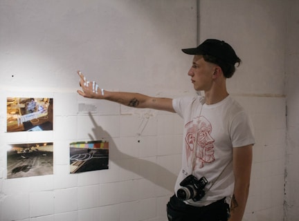 man in white crew neck t-shirt wearing black cap