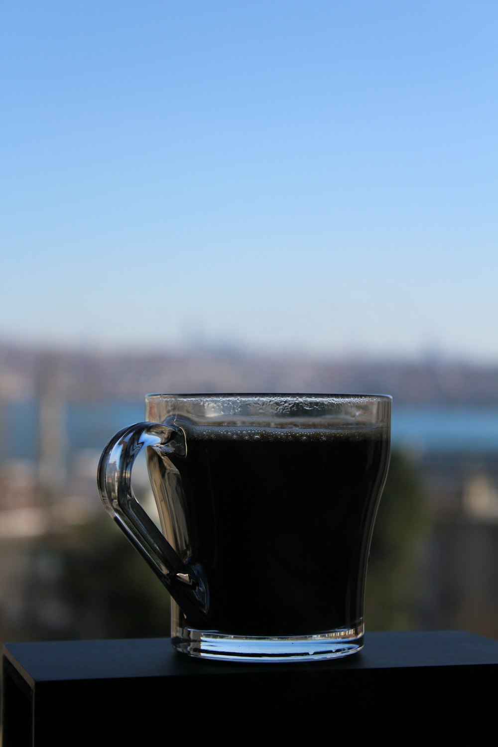 clear glass mug with black liquid