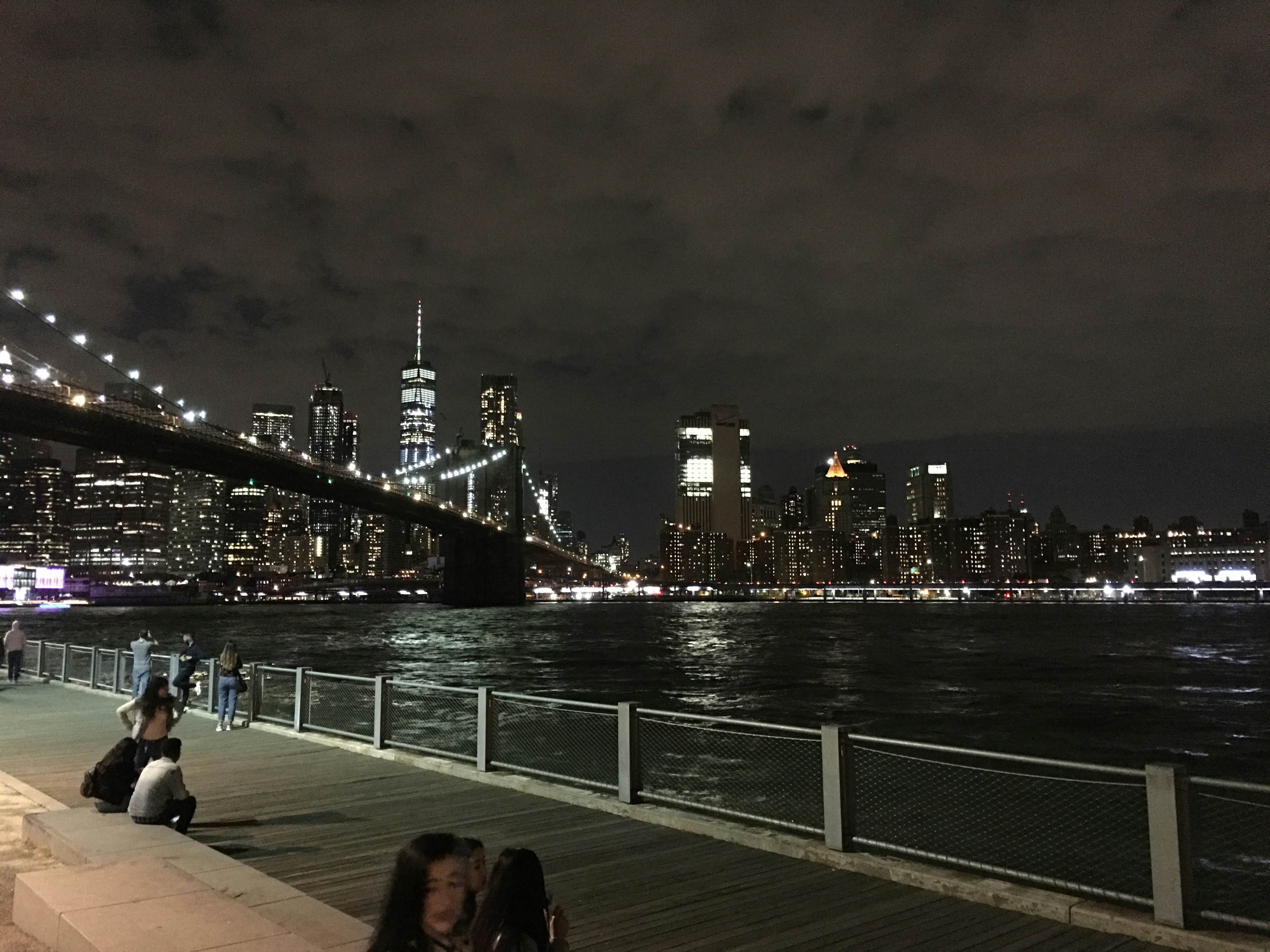 a group of people sitting on a pier next to a body of water