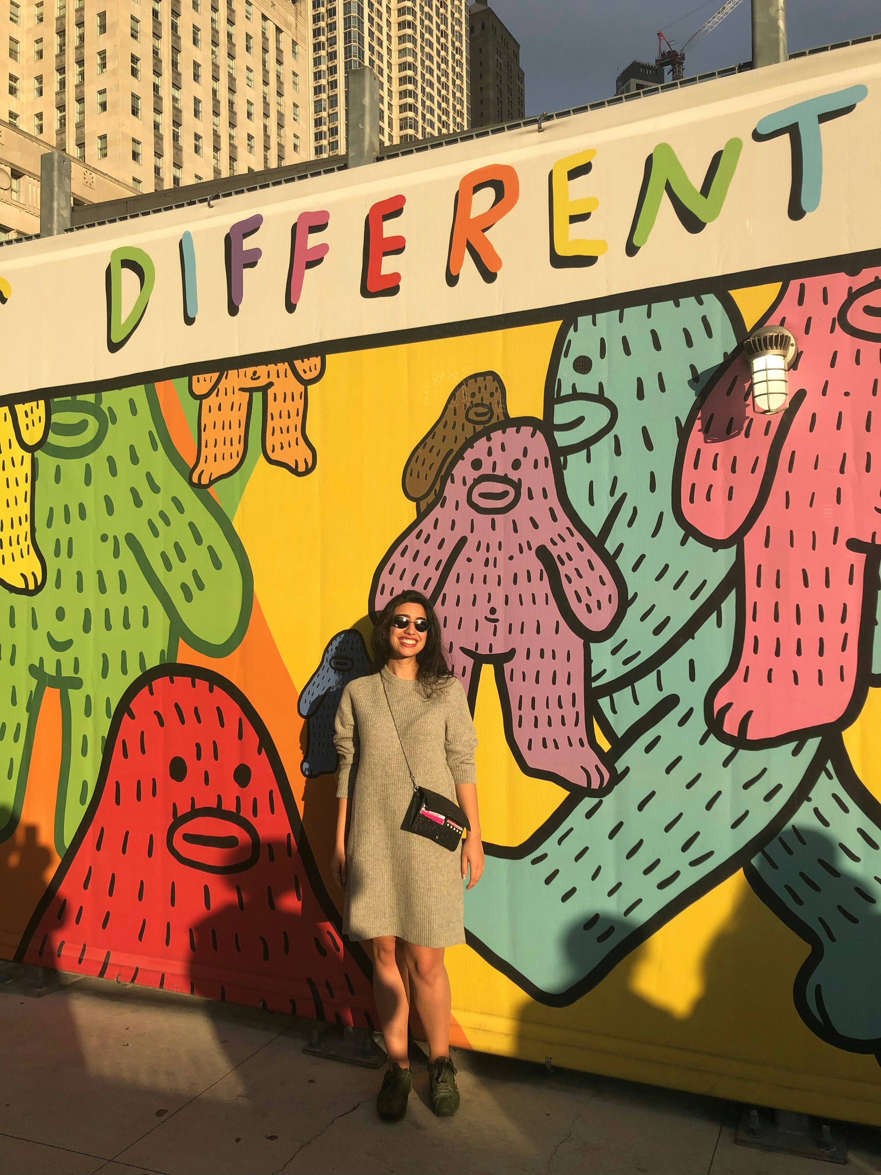 a woman standing in front of a colorful wall