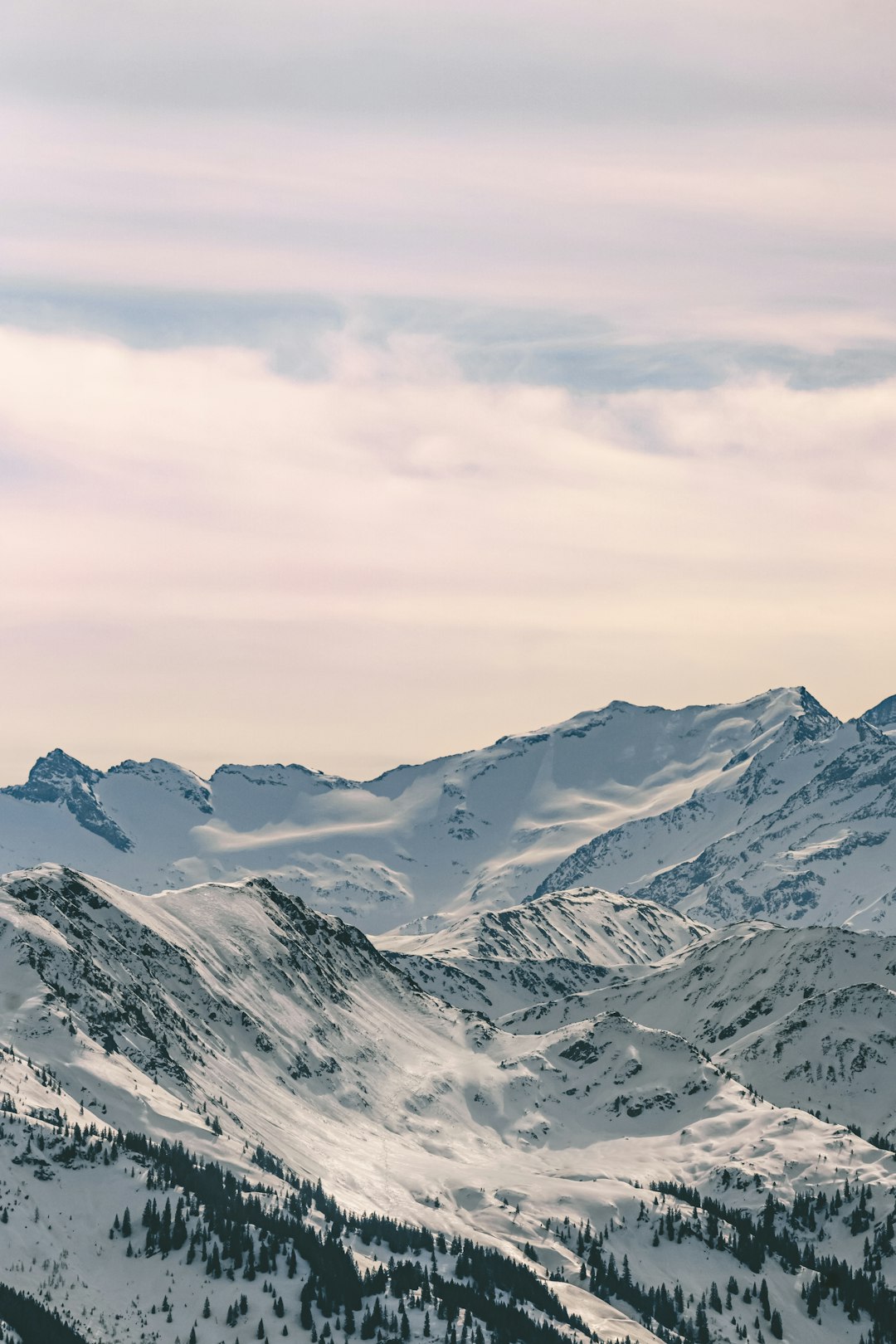 snow covered mountains under cloudy sky during daytime