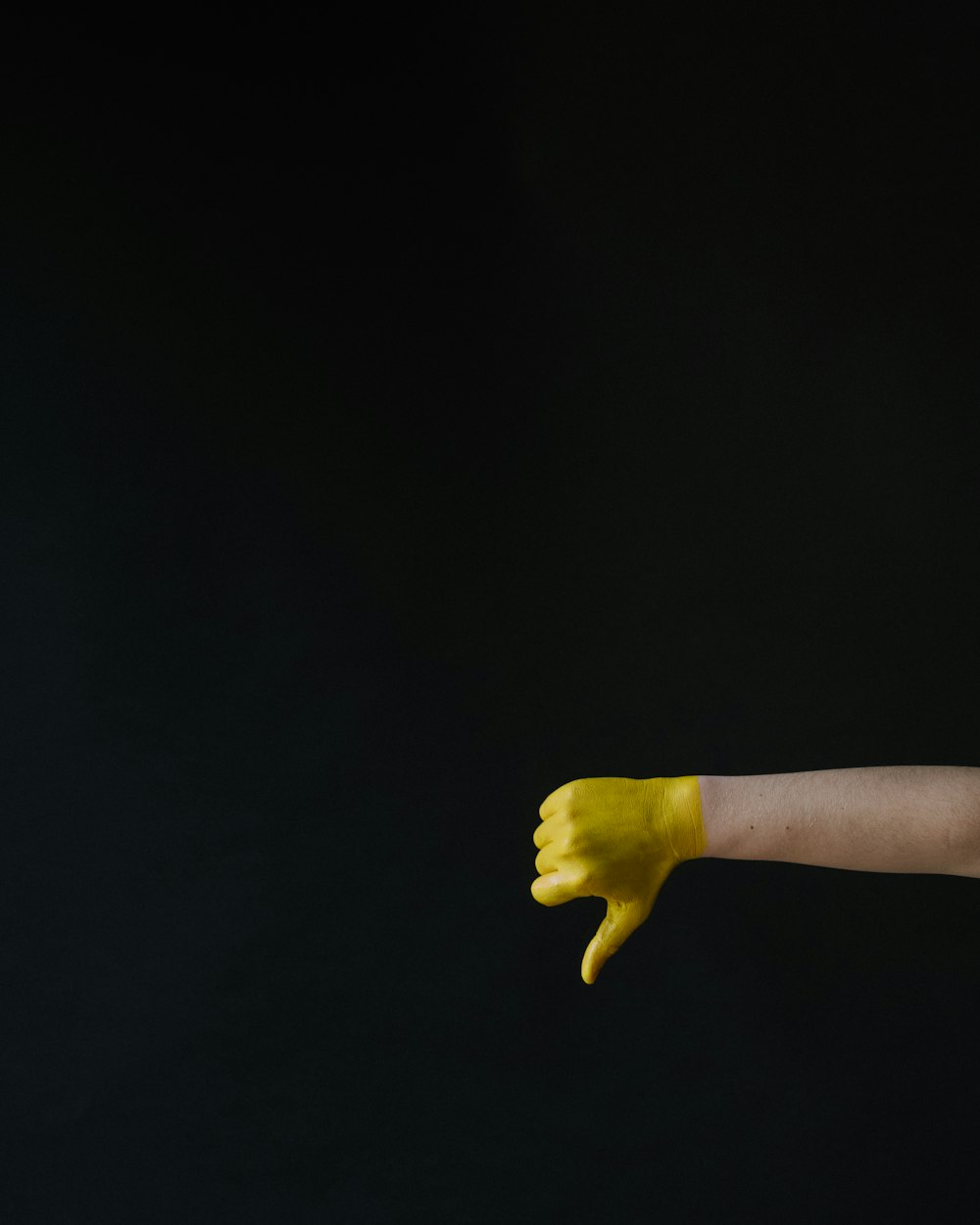 persons left hand with yellow paint