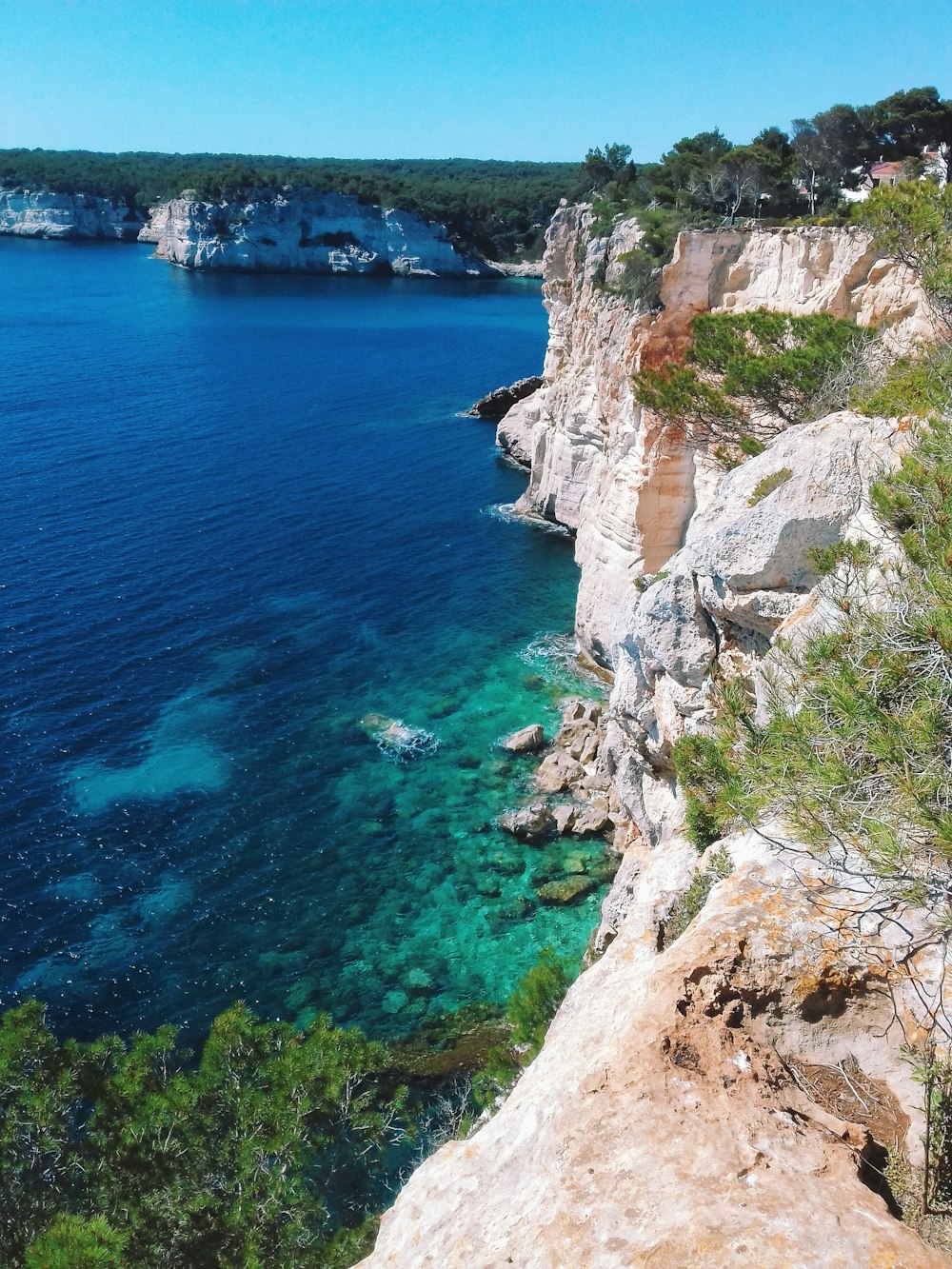 brown rocky mountain beside blue sea during daytime