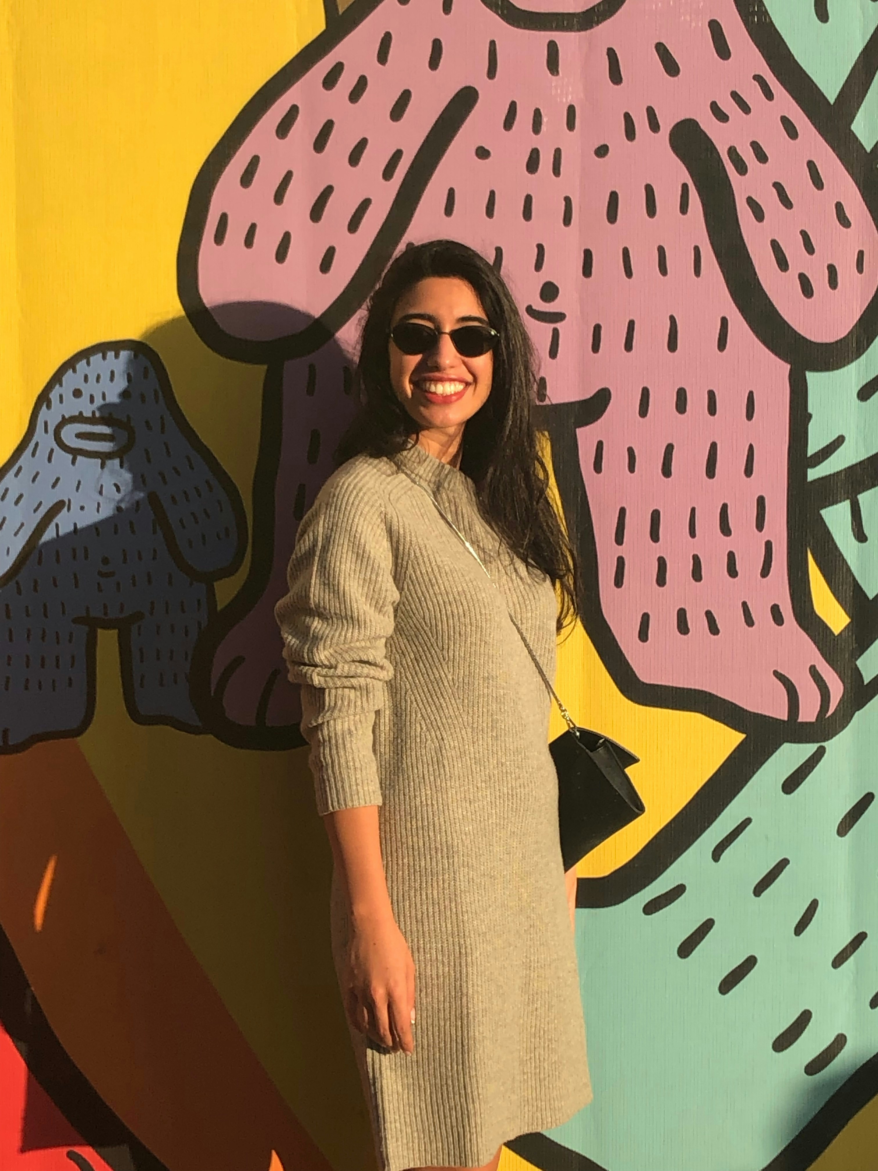 a woman standing in front of a colorful wall