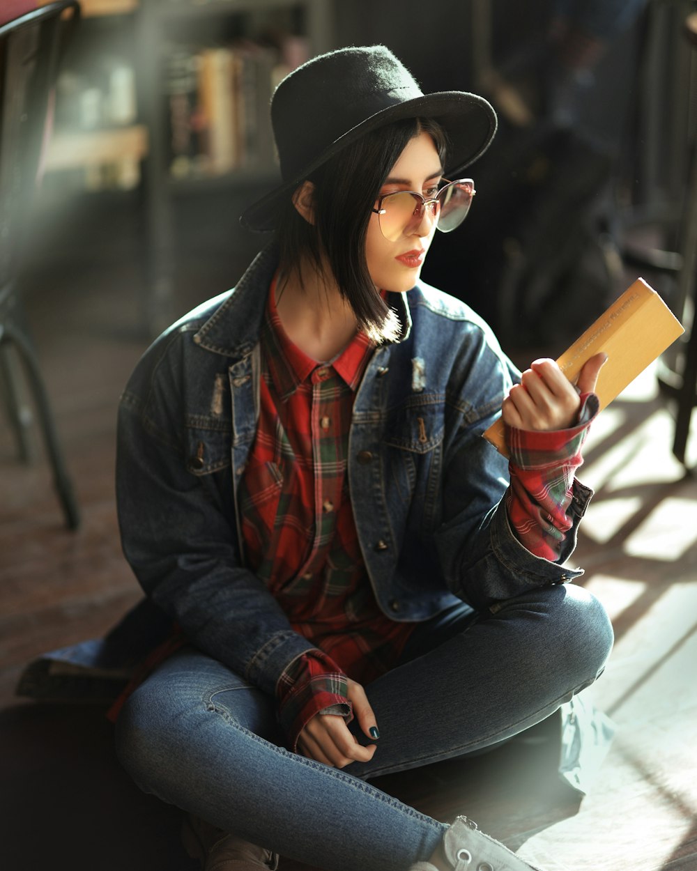 woman in blue denim jacket and blue denim jeans sitting on brown wooden bench during daytime