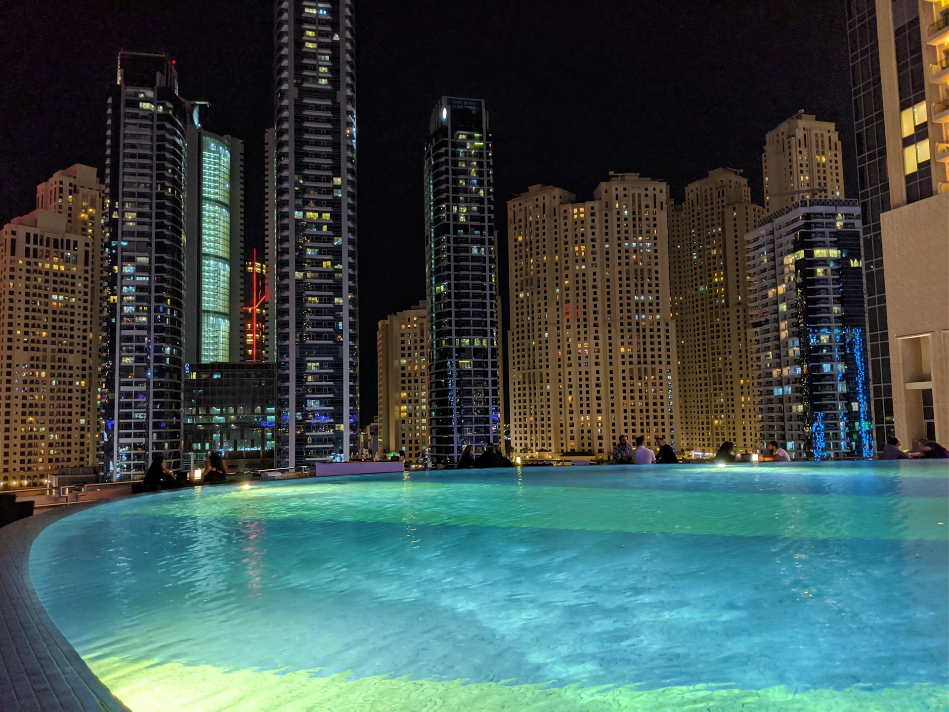 high rise buildings near body of water during night time