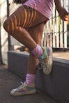 person in brown pants and white and pink nike sneakers