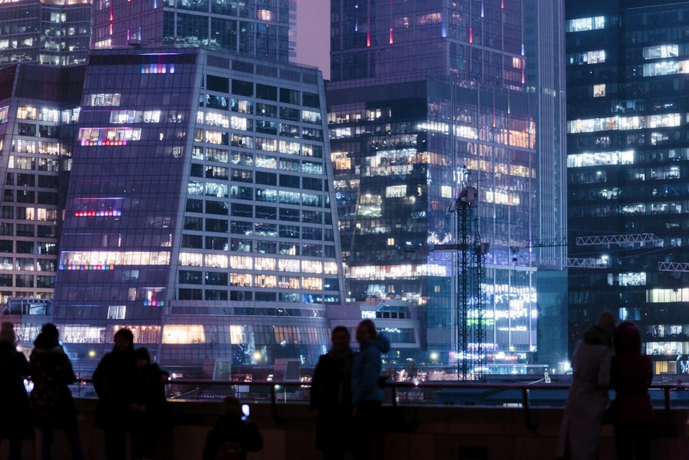 man in black jacket standing in front of building during night time