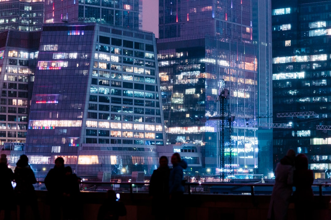 man in black jacket standing in front of building during night time