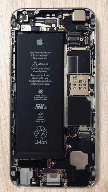 Close-up of hands replacing a smartphone battery inside the device