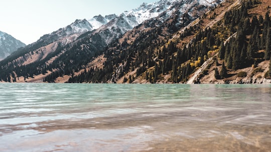 body of water near mountain during daytime in Ile-Alatau National Park Kazakhstan