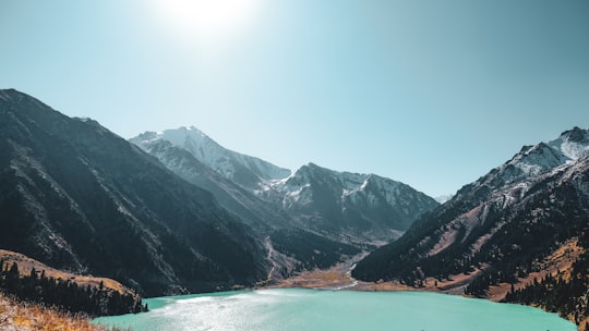 body of water near mountains during daytime in Ile-Alatau National Park Kazakhstan