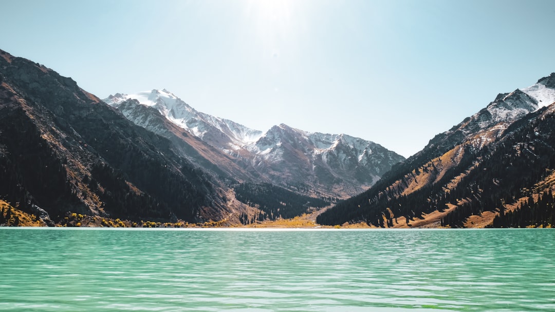 lake near snow covered mountains during daytime in Almaty Region Kazakhstan