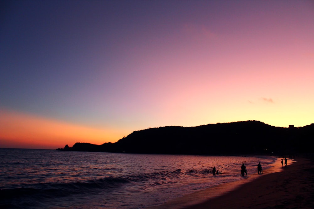 silhouette of people on beach during sunset