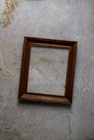 Handyman fixing a picture frame on a freshly painted wall.