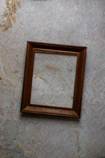 Handyman fixing a picture frame on a freshly painted wall.