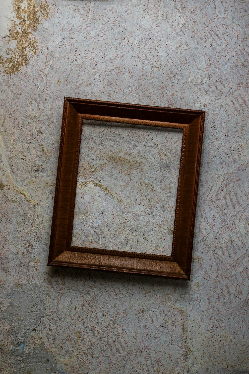 Cadre en bois marron sur mur blanc