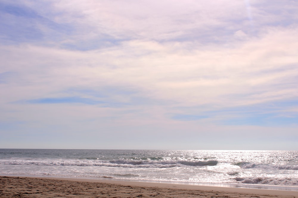 sea waves crashing on shore during daytime