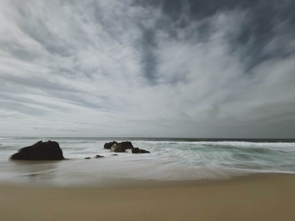 brown sand beach under cloudy sky during daytime