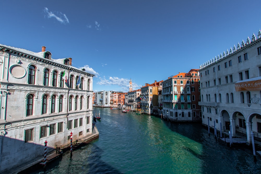 body of water between concrete buildings under blue sky during daytime