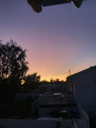 A serene backyard scene with an in-ground trampoline during sunset.