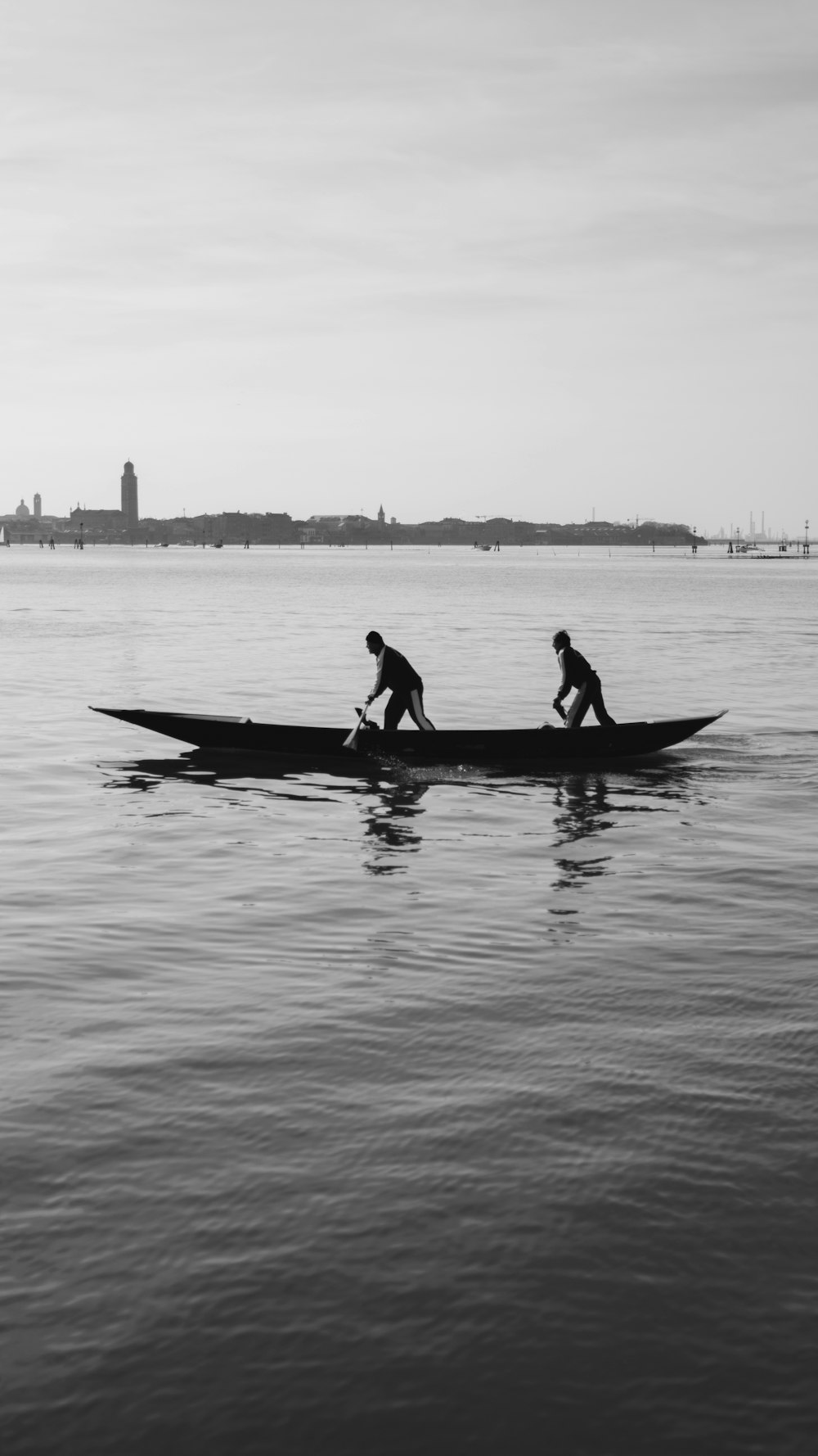 silhouette of 2 person riding on boat on water