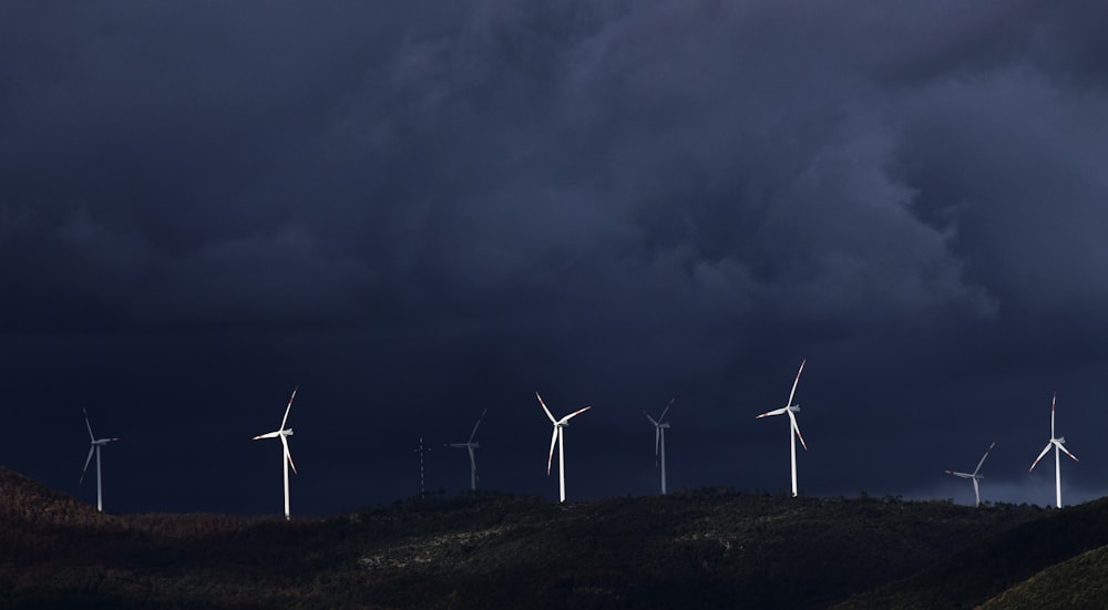 wind turbines on hill under gray sky