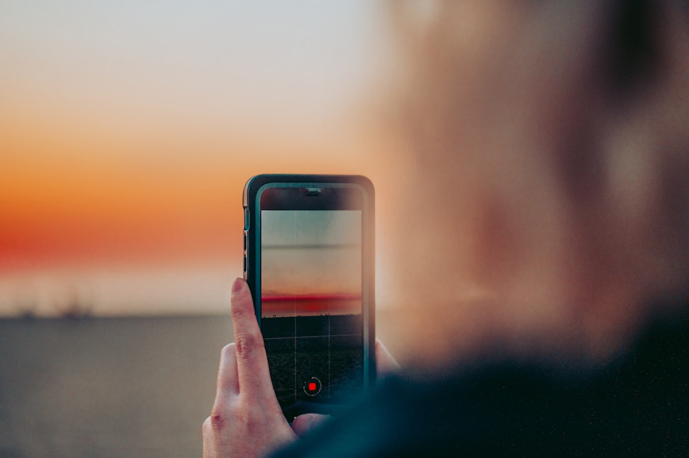 person holding black iphone 4