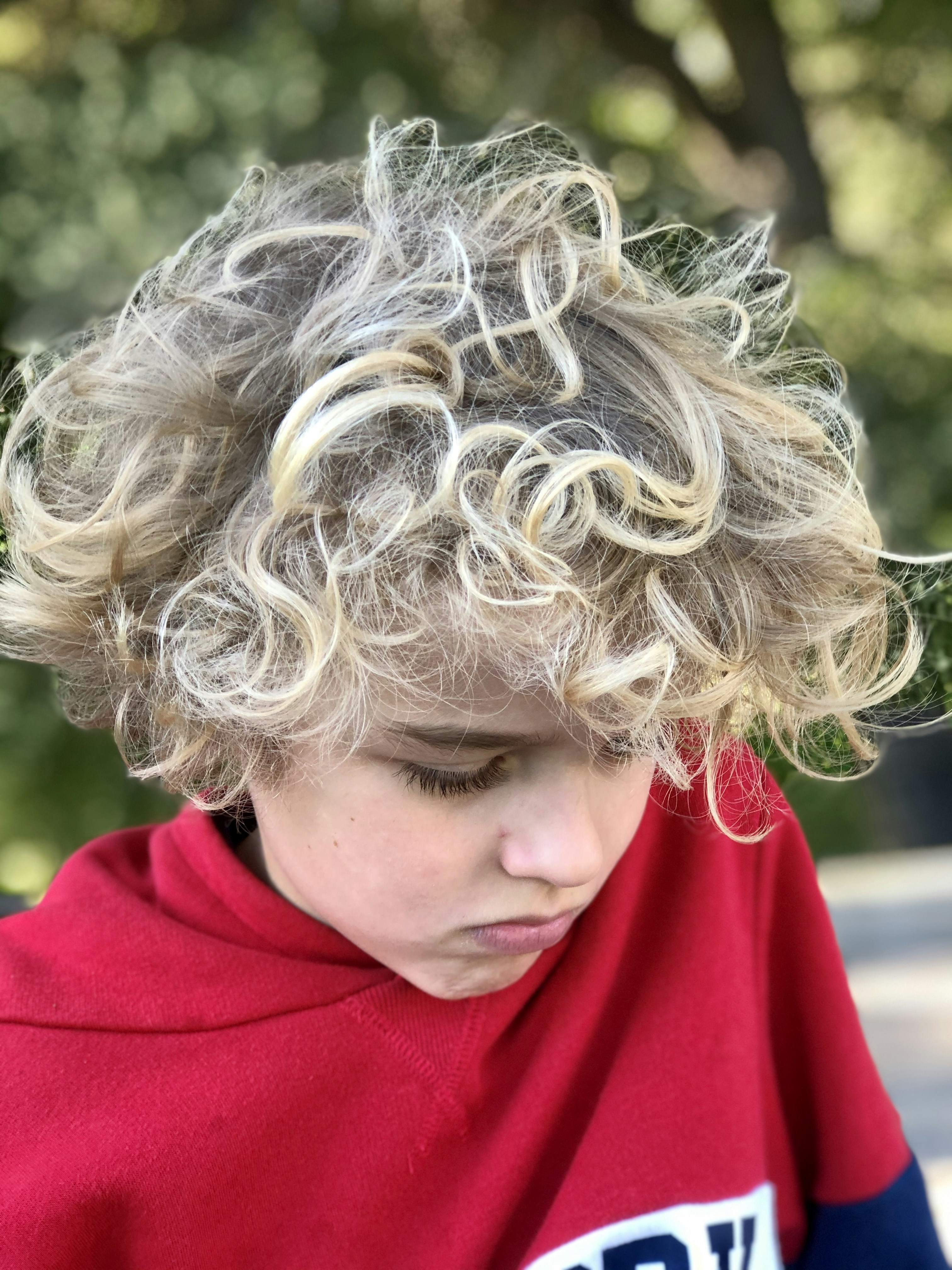 menino de cabelos loiros no capuz vermelho