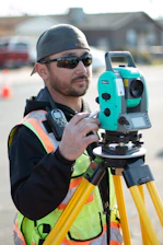man in black jacket holding blue and black camera