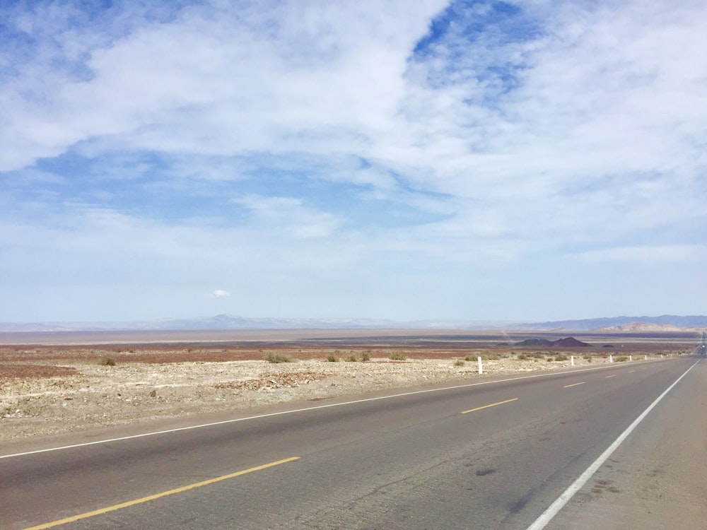 Carretera de asfalto gris bajo el cielo azul durante el día