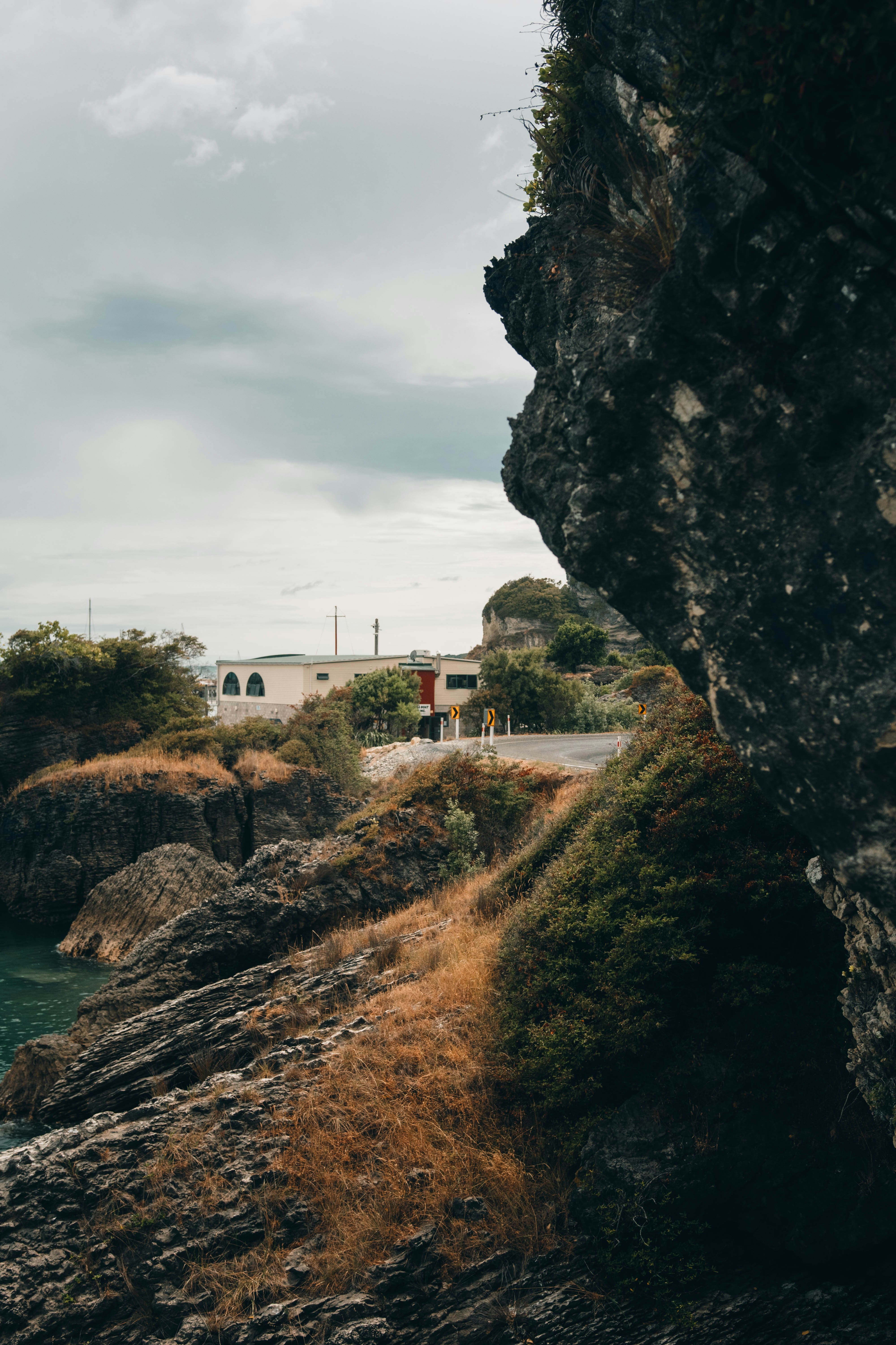 white concrete building near cliff and body of water during daytime