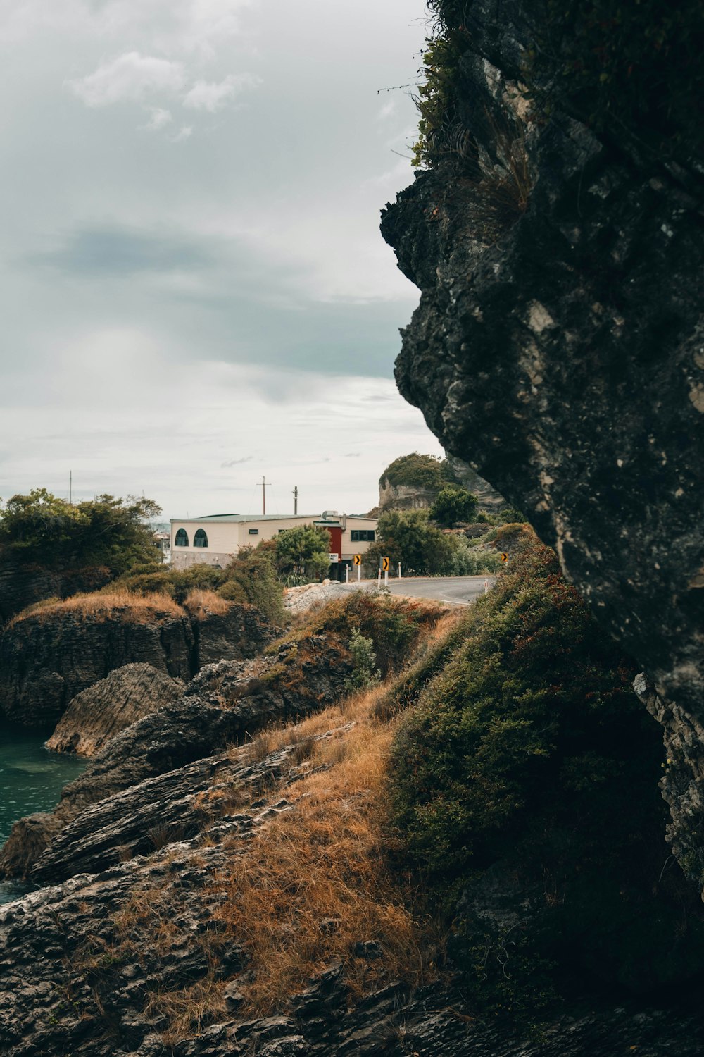 white concrete building near cliff and body of water during daytime