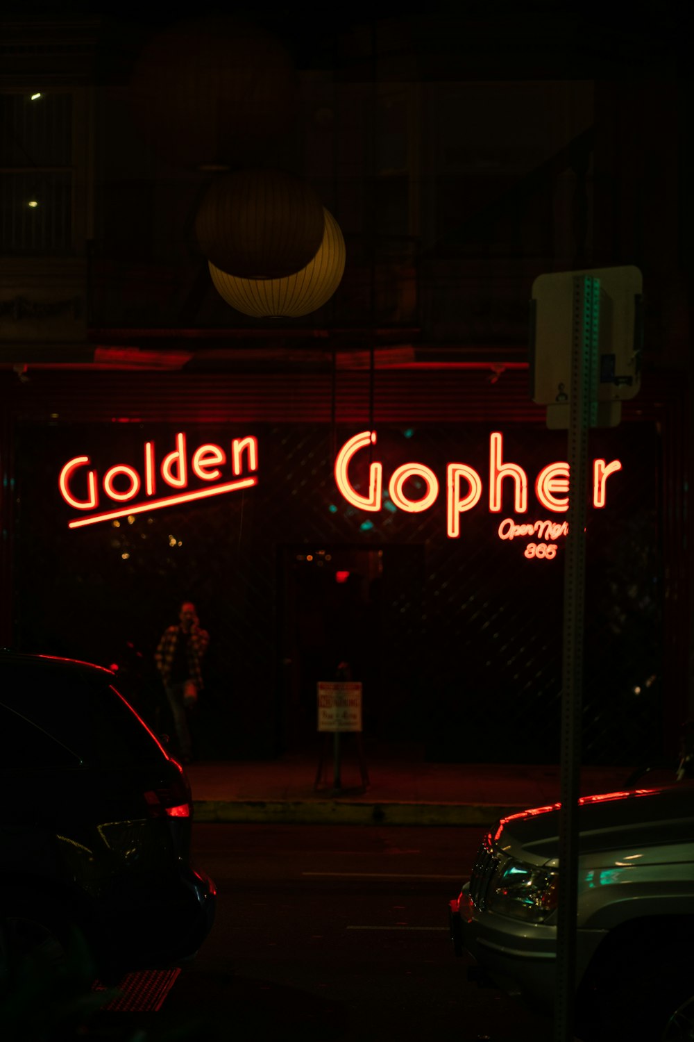 black car on road near white and red open signage during night time