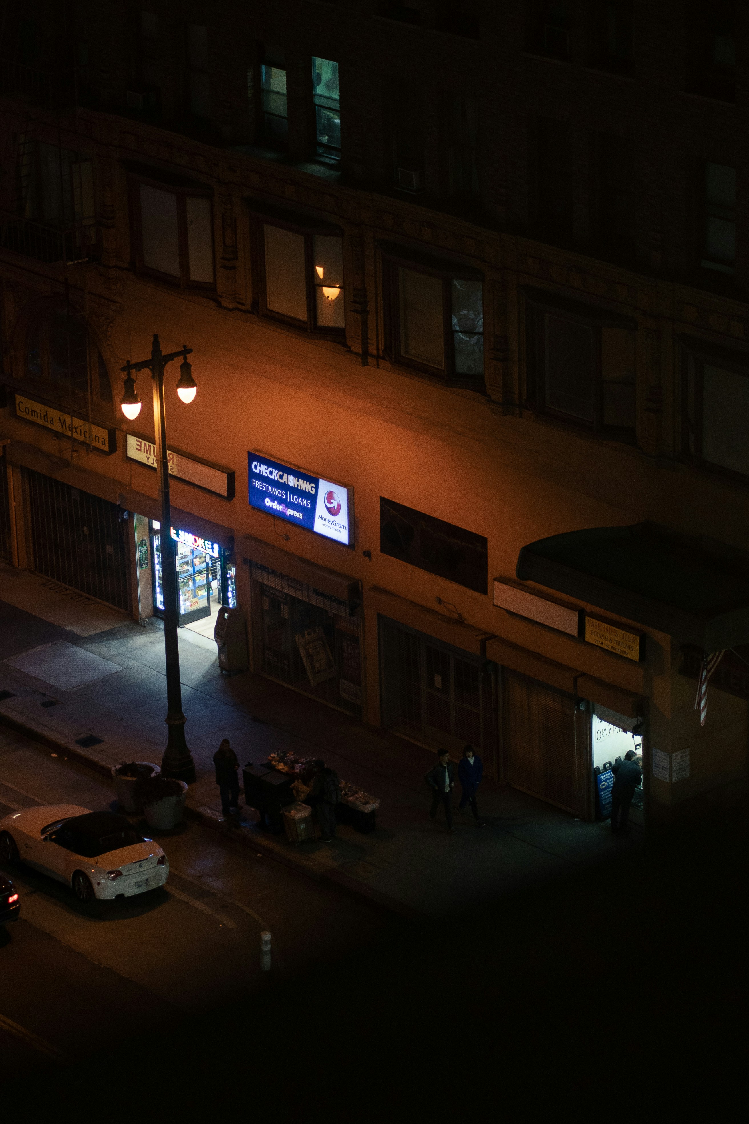people walking on sidewalk during night time