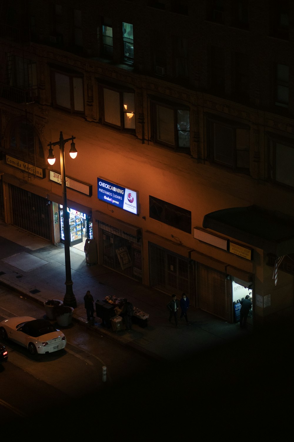 people walking on sidewalk during night time