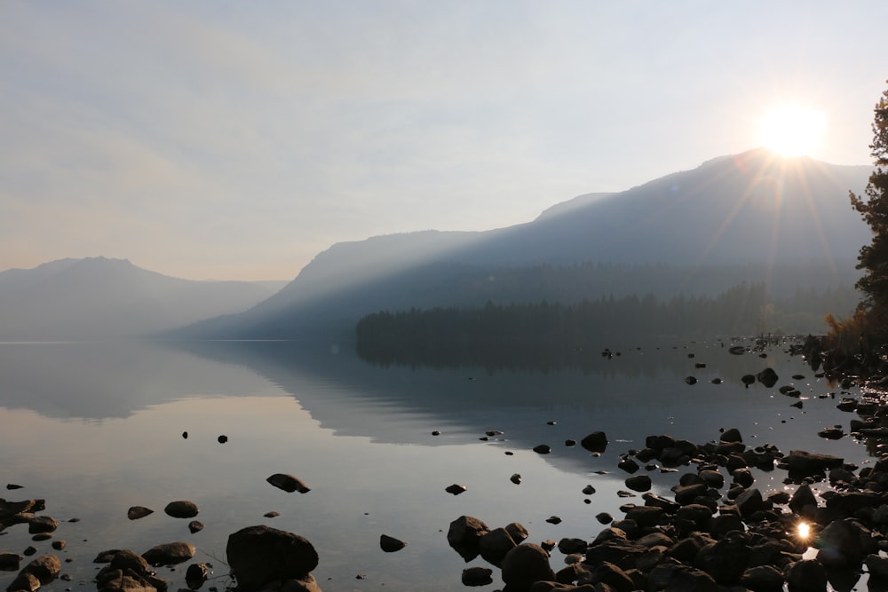 body of water near mountain during daytime