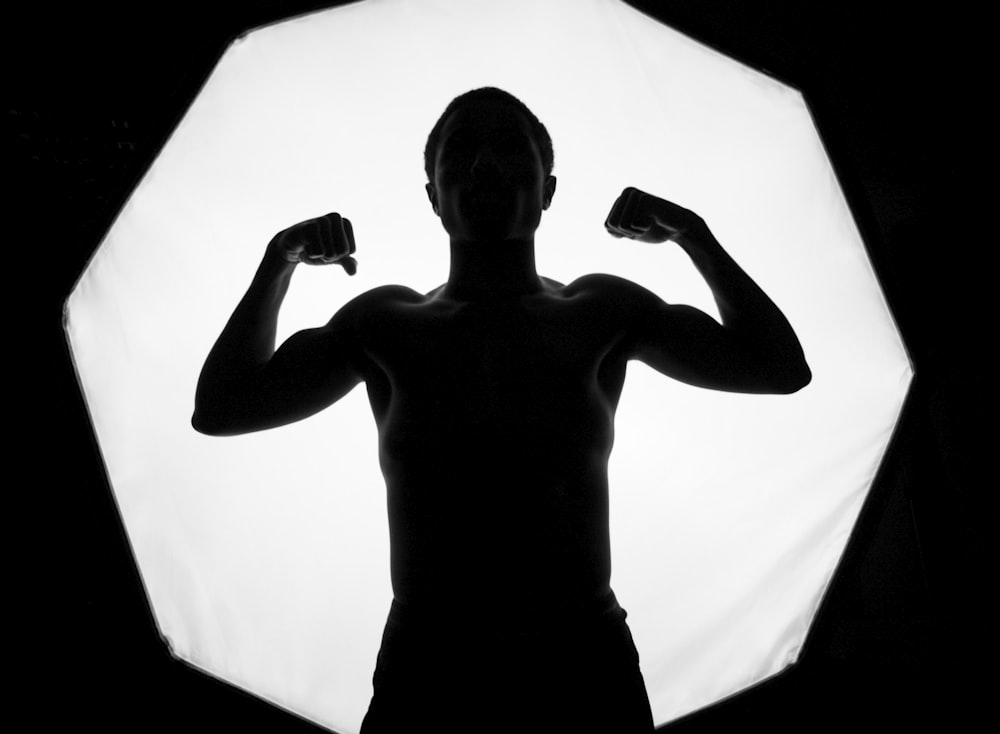 topless man holding black and white ceramic mug