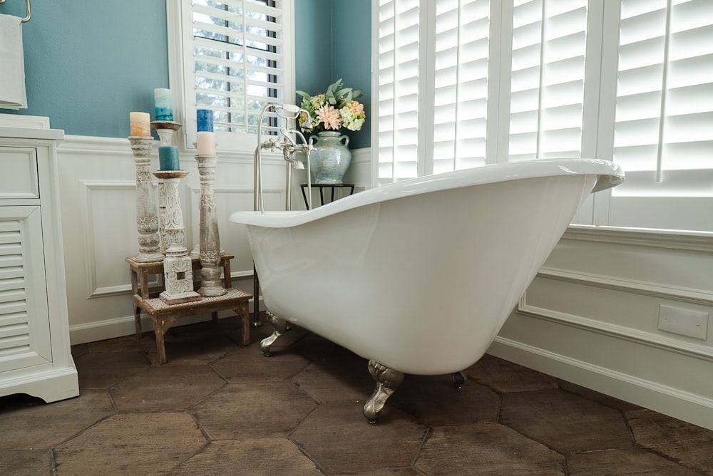 white bathtub near glass window