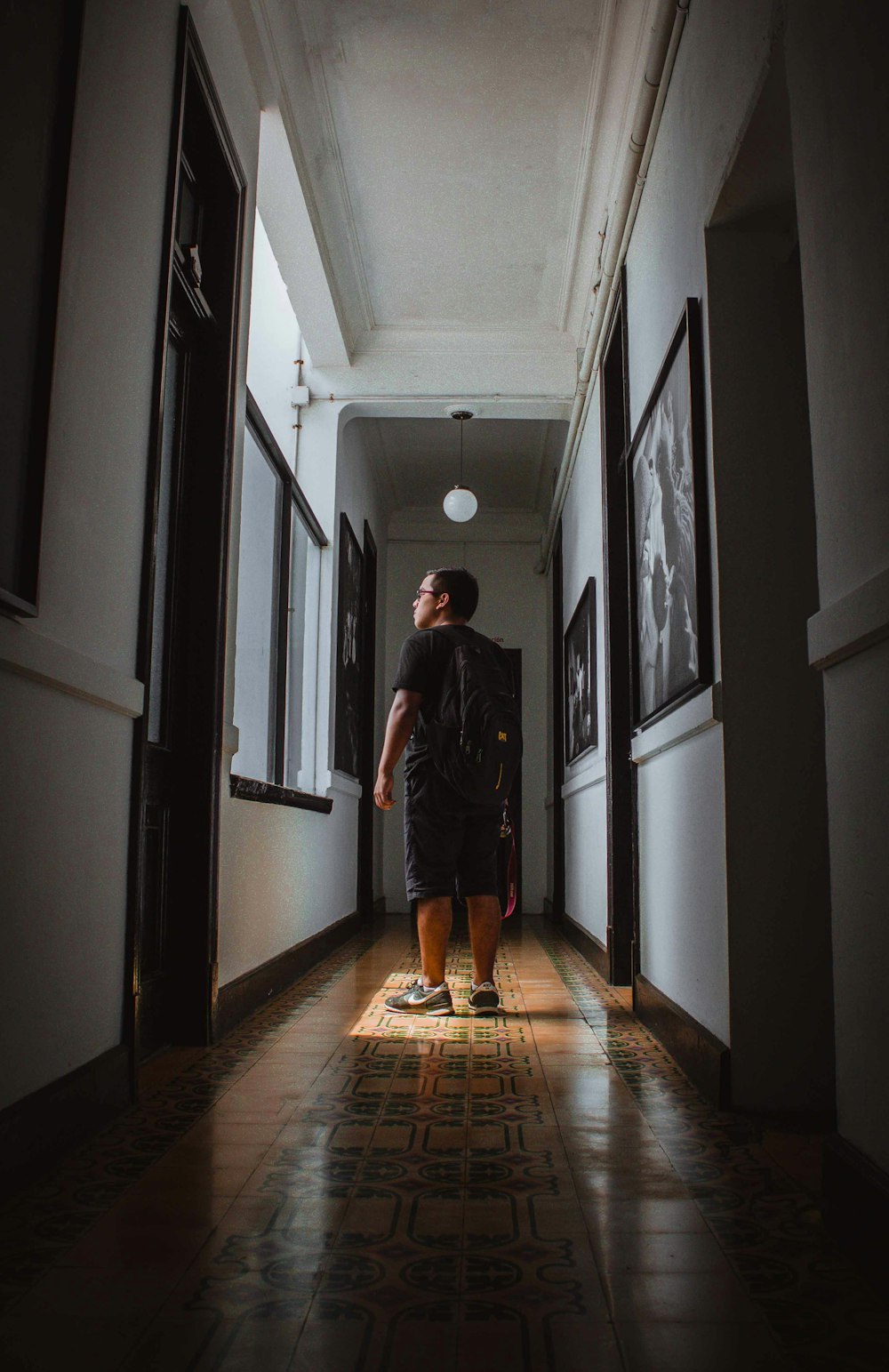 man in gray long sleeve shirt walking on hallway