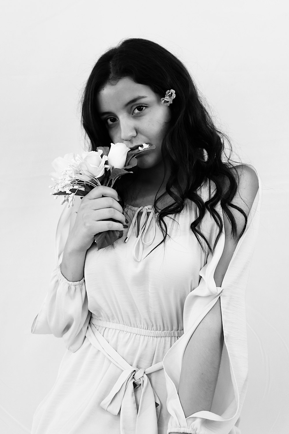 woman in white tank top holding flower