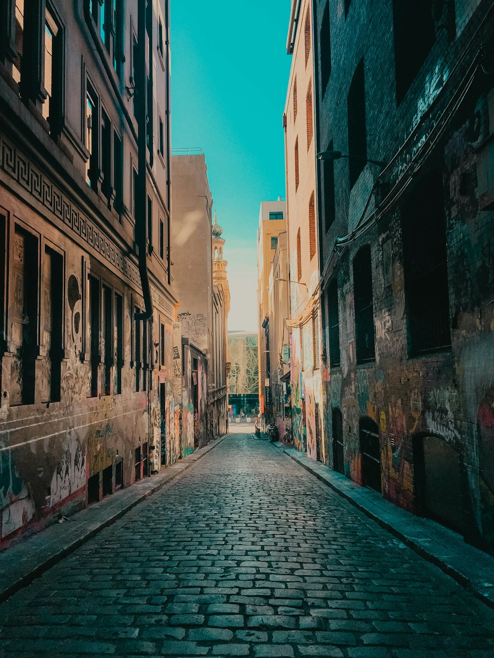 empty street between concrete buildings during daytime