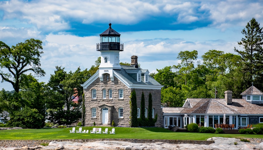 a light house sitting on top of a lush green field