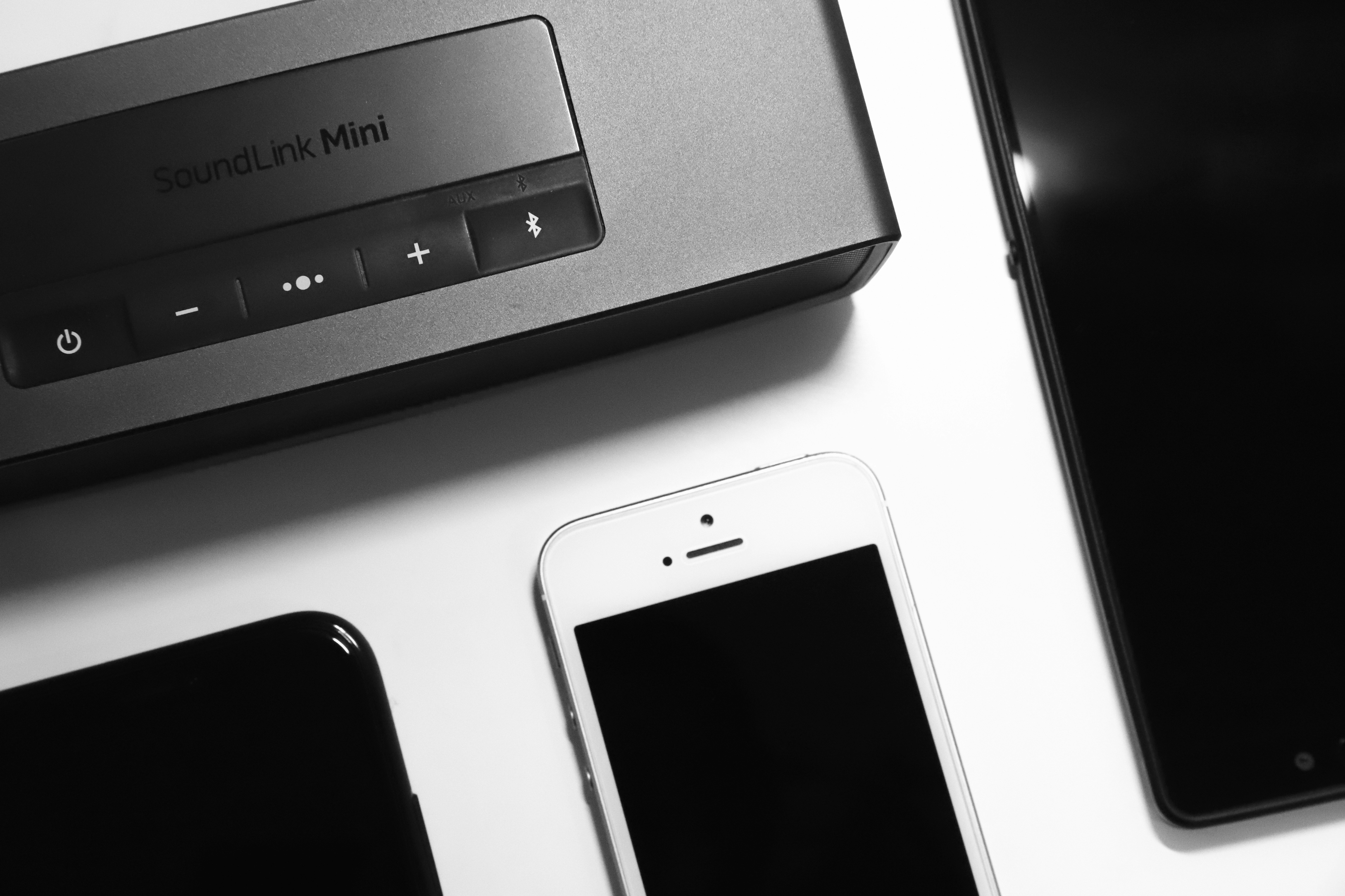 white iphone 5 beside gray sony speaker