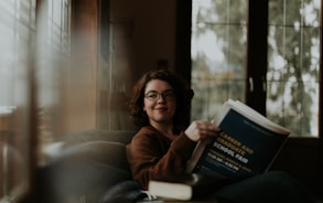 woman in brown coat using black laptop computer